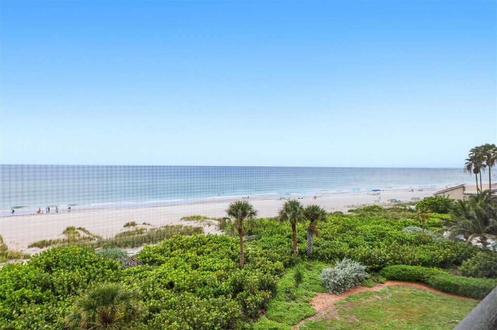 An elevated view of a sandy beach and ocean seen through a screened-in balcony — 4545 GULF OF MEXICO DRIVE UNIT 311, LONGBOAT KEY, FL