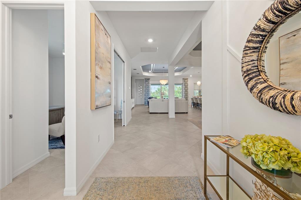 A bright entryway leads into an open-concept living area with light tile flooring — 7161 INLET ISLES COURT, LAKEWOOD RANCH, FL