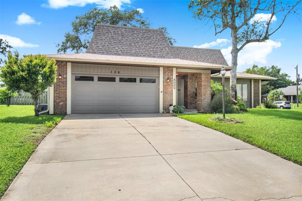 A single-story brick house with a two-car garage and a large concrete driveway — 126 FLORIDA PARK DRIVE, PALM COAST, FL