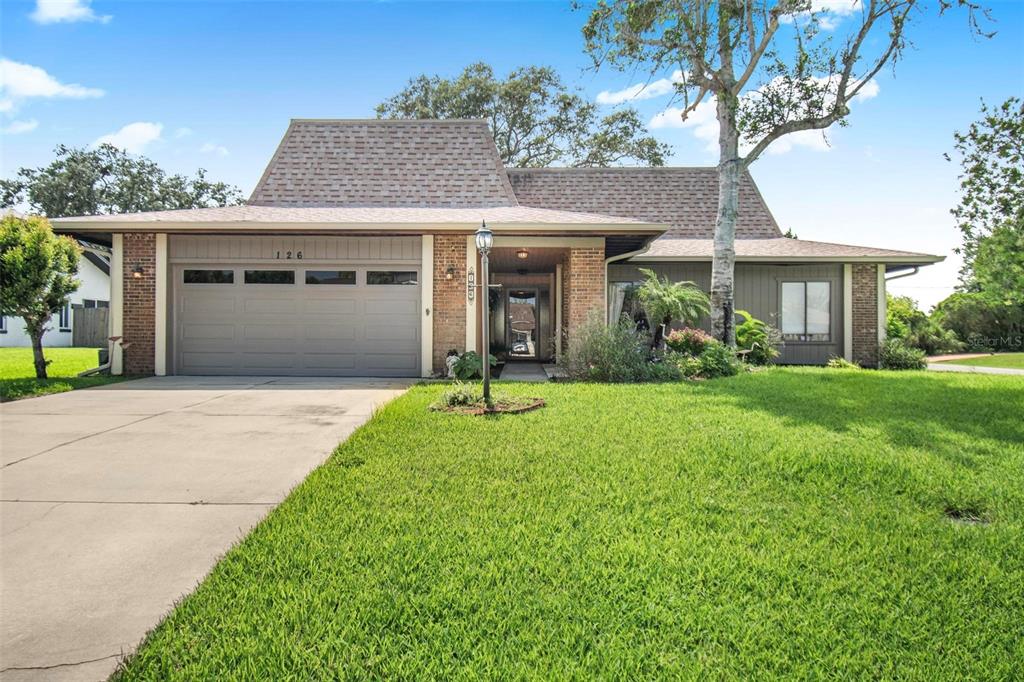 A single-story house with a brick and wood exterior, a two-car garage, and a lawn — 126 FLORIDA PARK DRIVE, PALM COAST, FL