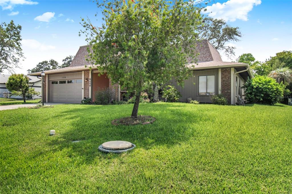 A single-story house with a brown shingled roof, tan siding, and a two-car garage — 126 FLORIDA PARK DRIVE, PALM COAST, FL