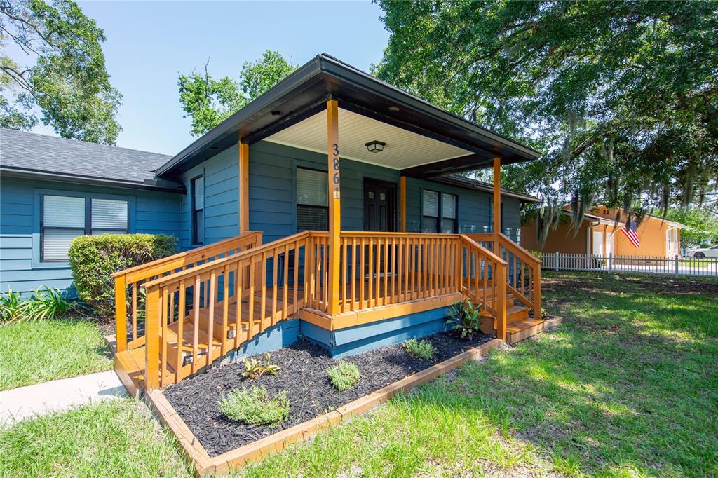 A blue house features a wooden porch with stairs and a ramp under a roof — 3861 GALICIA ROAD, JACKSONVILLE, FL