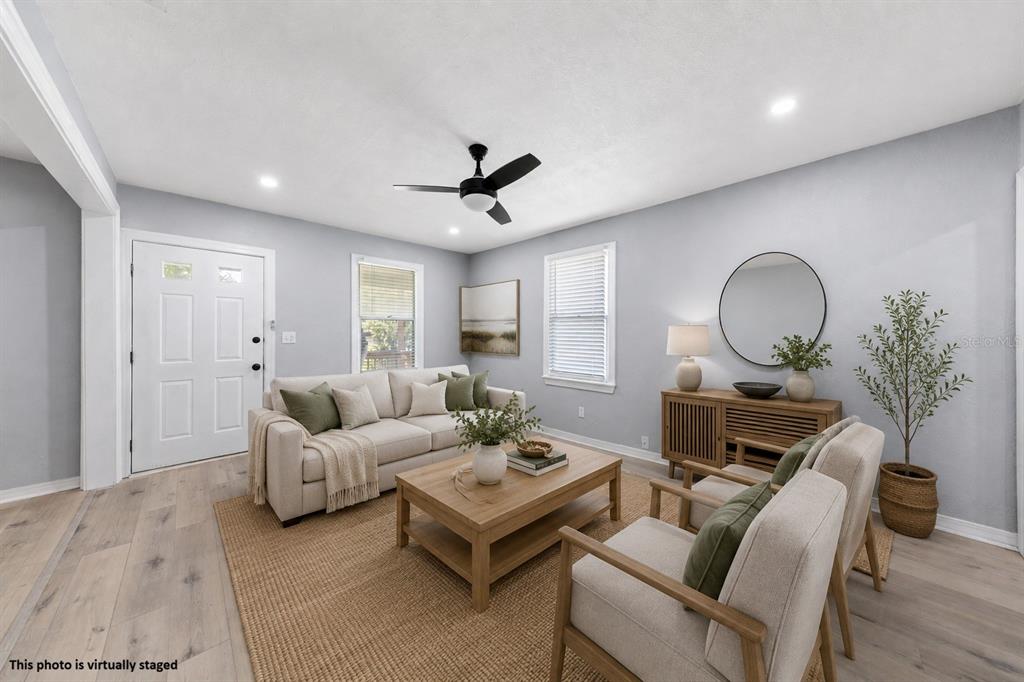 A living room with light wood floors, a sofa, two armchairs, and a coffee table — 3861 GALICIA ROAD, JACKSONVILLE, FL
