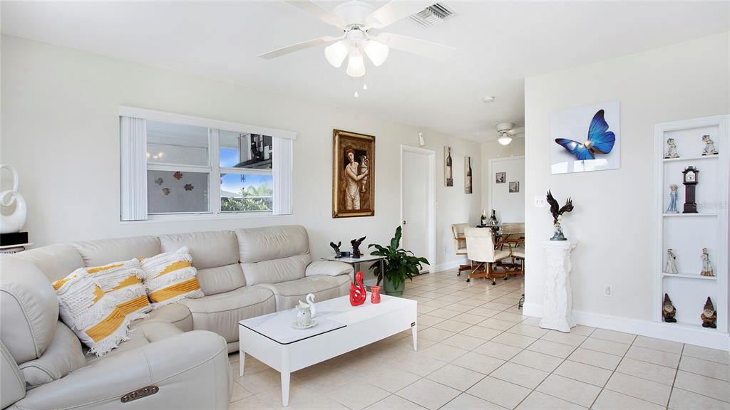 A living room features a white leather sofa, a coffee table, and tile flooring — 515 YORK ROAD, LEHIGH ACRES, FL