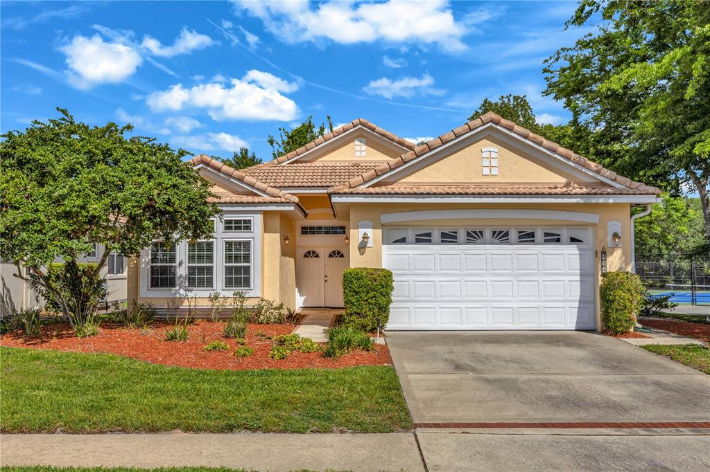 A single-story house with a beige stucco exterior, a tile roof, and a two-car garage — 414 FAIRLANE DRIVE, DEBARY, FL