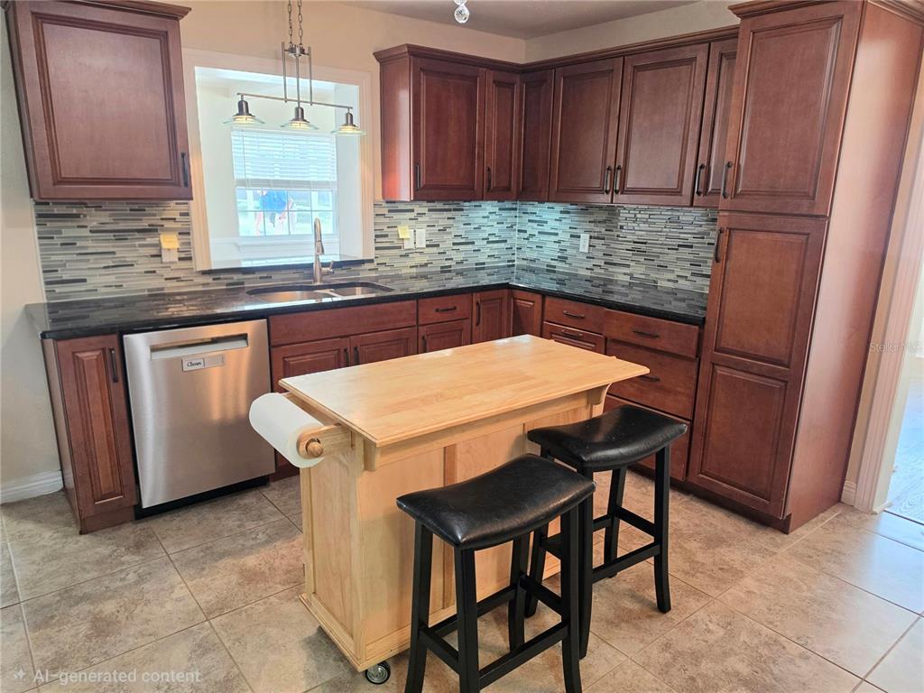 A kitchen features dark wood cabinets, black countertops, a tiled backsplash, and a portable island — 100 ALACHUA DRIVE, WINTER HAVEN, FL