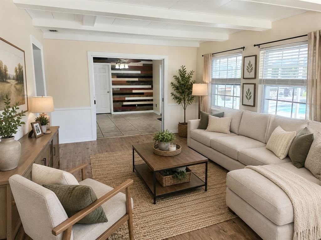 A living room features a sectional sofa, wood coffee table, and a view into another room — 100 ALACHUA DRIVE, WINTER HAVEN, FL