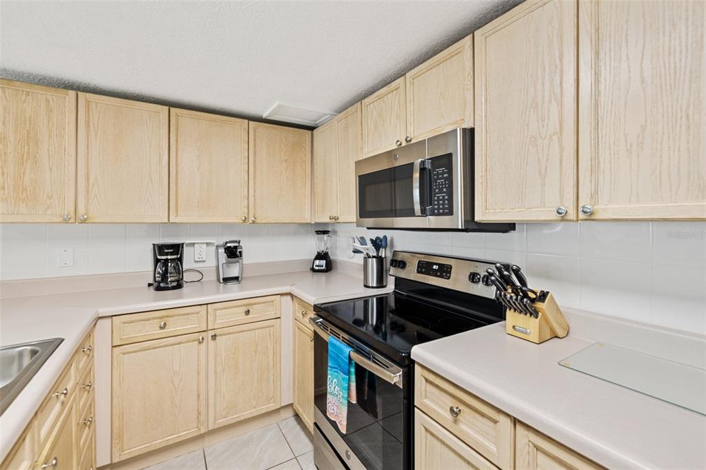 A kitchen features light wood cabinets, laminate countertops, and stainless steel appliances — 5300 S ATLANTIC AVENUE UNIT 1-505, NEW SMYRNA BEACH, FL