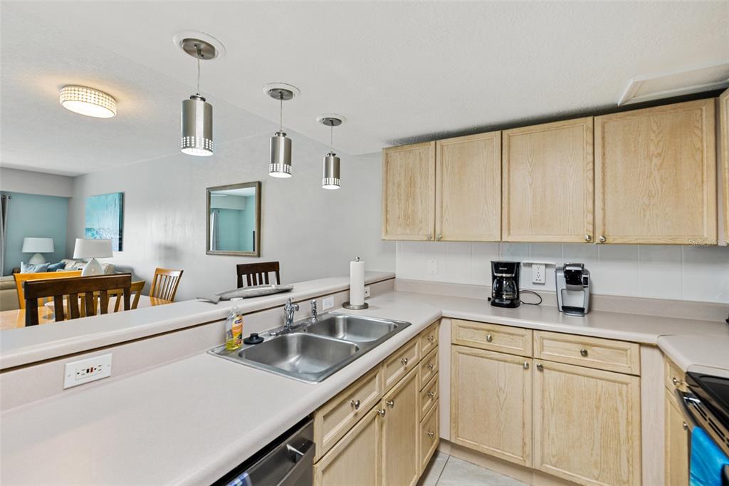 A kitchen features light wood cabinets, a double-basin sink, and three pendant lights above — 5300 S ATLANTIC AVENUE UNIT 1-505, NEW SMYRNA BEACH, FL