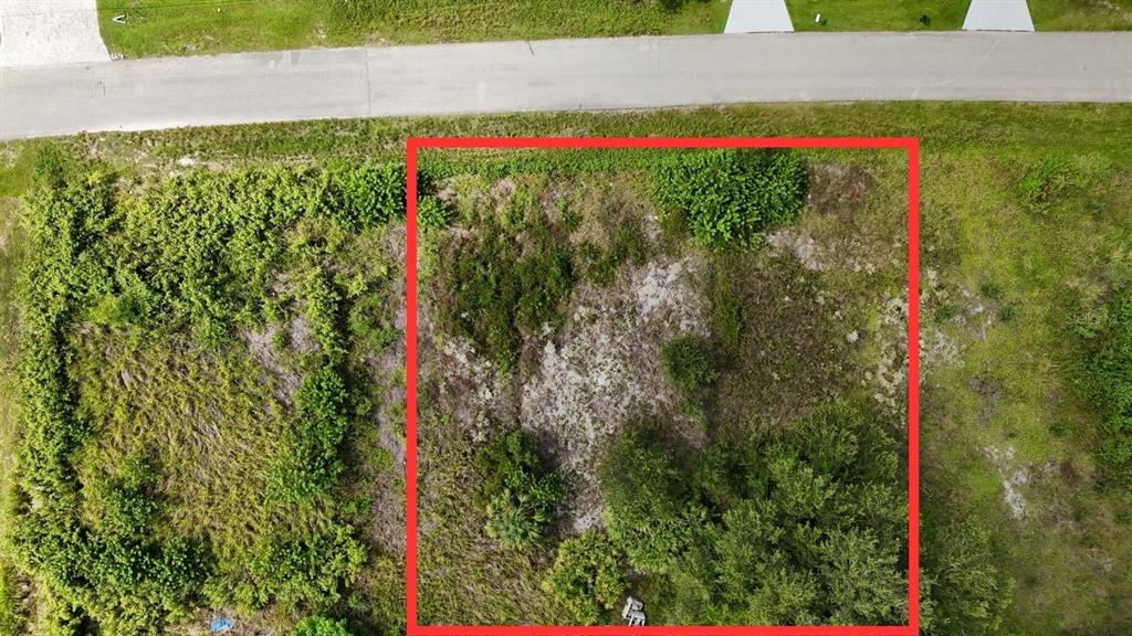 An aerial view shows a rectangular, undeveloped plot of land bordered by a paved road — 4452 28TH STREET SW, LEHIGH ACRES, FL