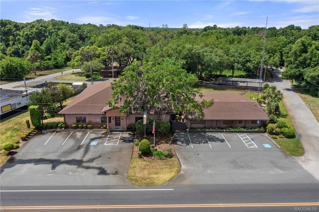 An aerial view shows a single-story brick commercial building with a parking lot and trees — 62 HIGHWAY 40 W, INGLIS, FL