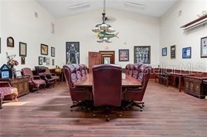 A conference room features a long wooden table surrounded by leather chairs under a chandelier — 62 HIGHWAY 40 W, INGLIS, FL