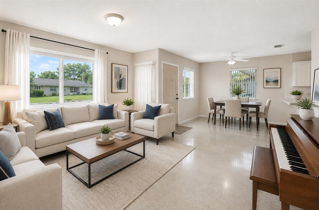 A kitchen with white cabinets and a black stove opens into a dining area — 12155 BAGDAD STREET, SPRING HILL, FL