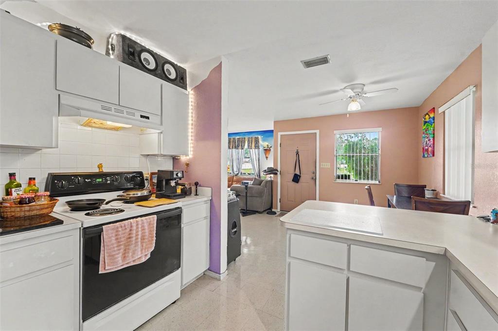 A backyard with a fire pit, mature trees, and a beige house with a wooden fence — 12155 BAGDAD STREET, SPRING HILL, FL