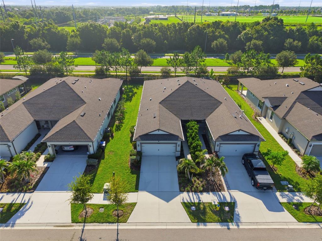 An aerial view shows three suburban houses with gray roofs, driveways, and green lawns — 6352 MOORING LINE CIRCLE, APOLLO BEACH, FL