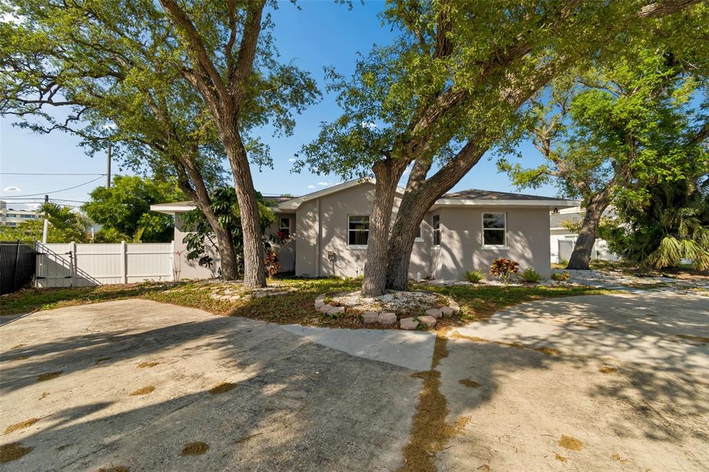 A single-story house with a concrete driveway and large mature trees in the front yard — 125 HARBOR BLUFF DRIVE, LARGO, FL