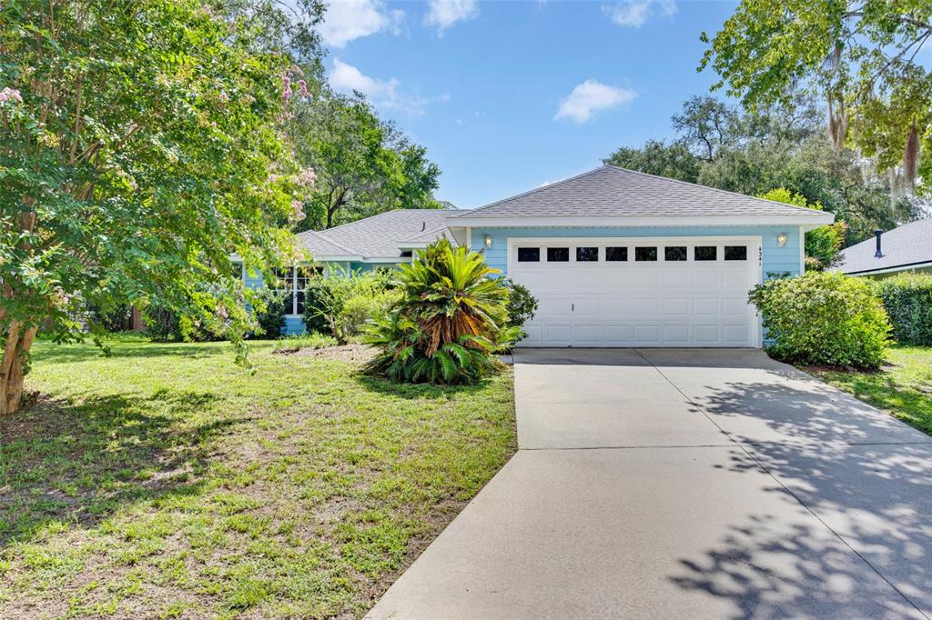 A light blue single-story house features a white two-car garage and a concrete driveway — 4341 NW 34TH TERRACE, GAINESVILLE, FL