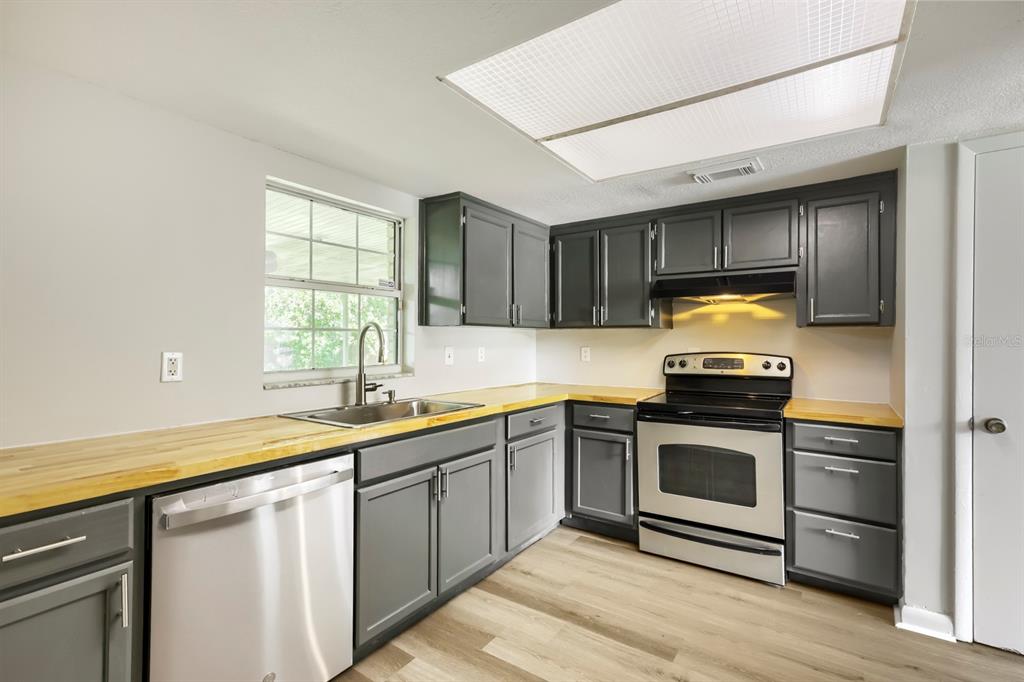 A kitchen with gray cabinets, wood countertops, stainless steel appliances, and a window above the sink — 1418 OAK VALLEY DRIVE, SEFFNER, FL
