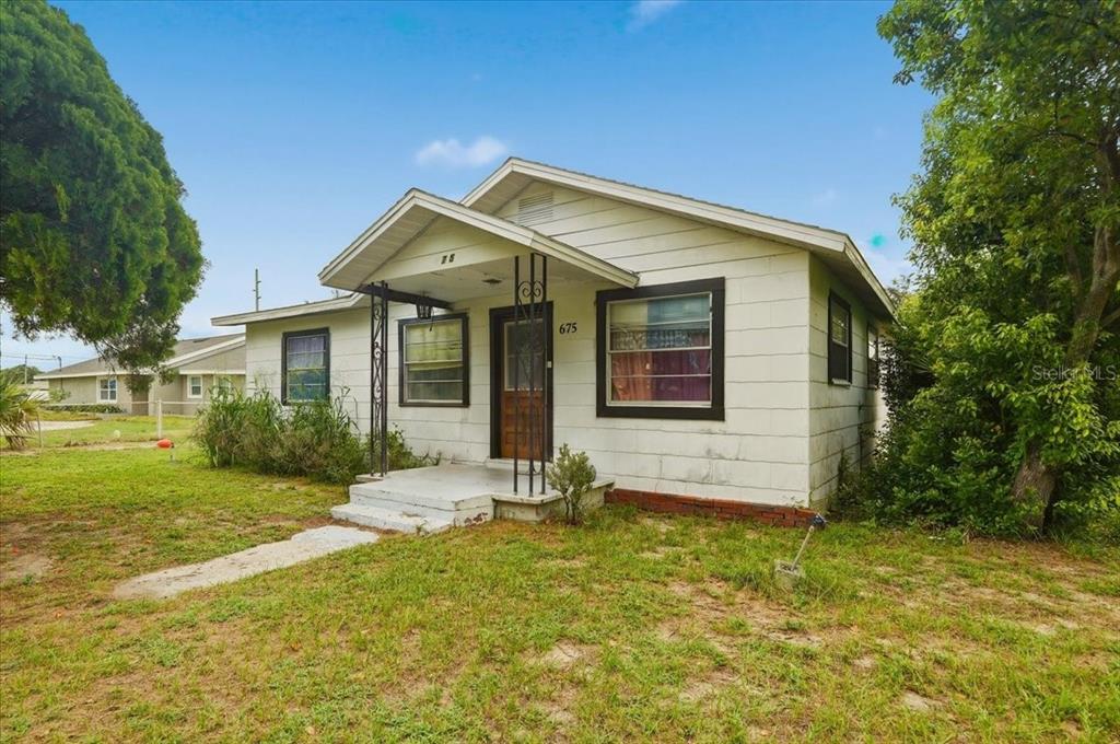 A single-story house with white siding, a small front porch, and a brown front door — 675 E BAY AVENUE, EAGLE LAKE, FL