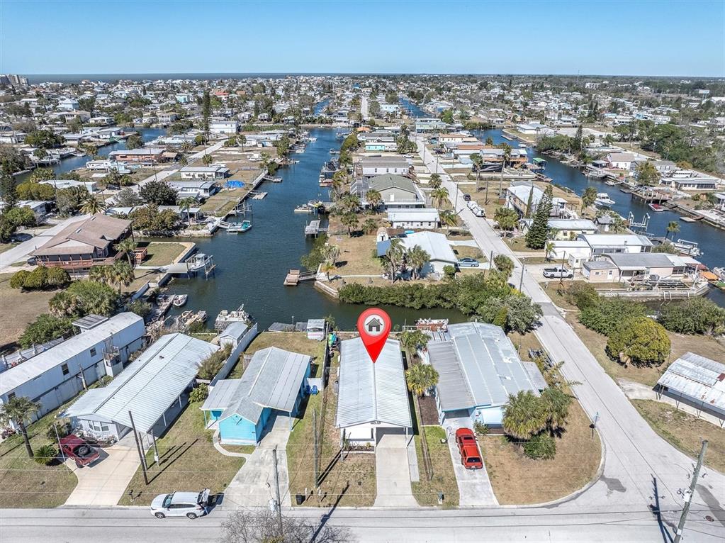 An aerial view shows a row of manufactured homes along a canal in a neighborhood — 6627 TOWER DRIVE, HUDSON, FL