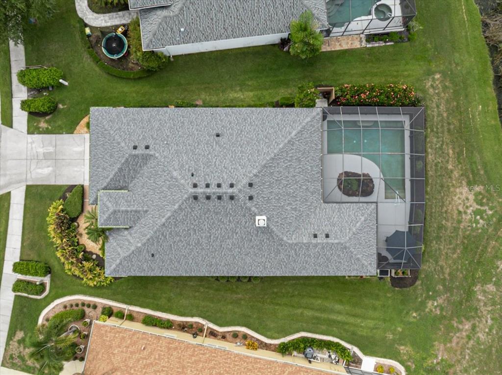 An aerial view shows a house with a gray shingled roof and a screened-in pool — 12319 LAVENDER LOOP, BRADENTON, FL