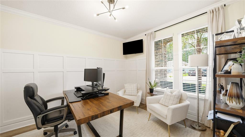 A home office features a wooden desk, two white armchairs, and white wainscoting on walls — 2931 LAS CALINAS BOULEVARD, ST AUGUSTINE, FL
