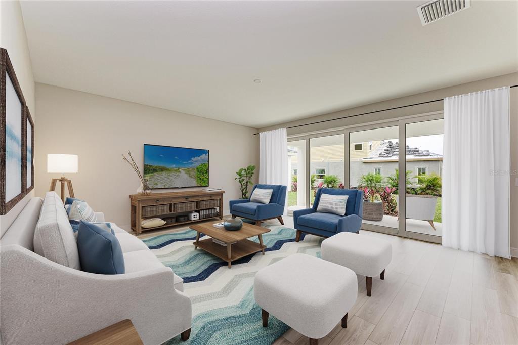 This rendering shows a living room with a sofa, two blue armchairs, and sliding glass doors — 10186 SURREY ROSE DRIVE, SAN ANTONIO, FL