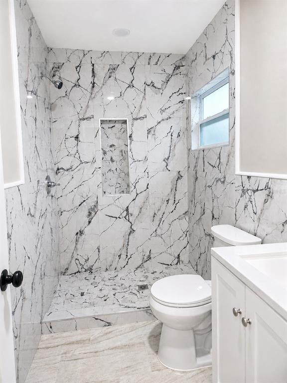 A bathroom features a walk-in shower with black and white marble tile and a vanity — 2103 45TH STREET COURT E, BRADENTON, FL