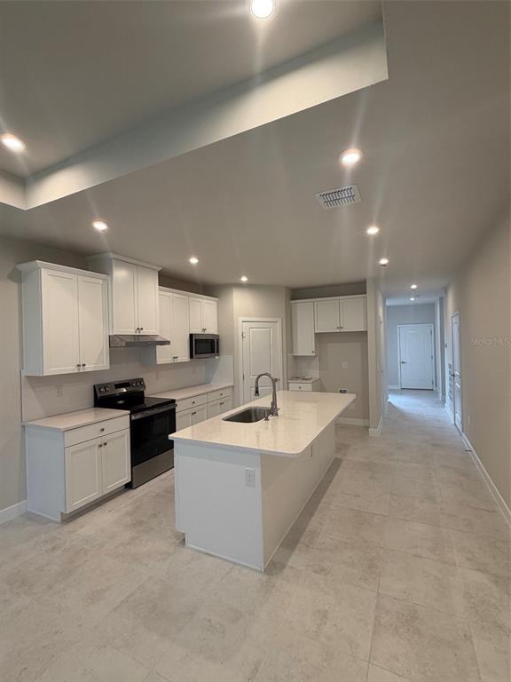 A duplex home with light gray siding, two garage doors, and a central landscaped walkway — 18740 HIGHLAND DEW STREET, SPRING HILL, FL