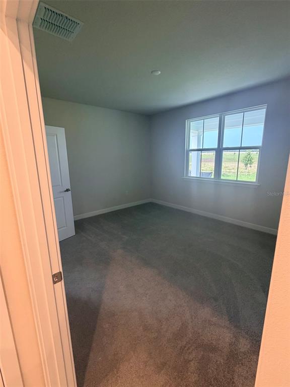 A living room features a light gray sofa, two armchairs, a wooden coffee table, and large windows — 18740 HIGHLAND DEW STREET, SPRING HILL, FL