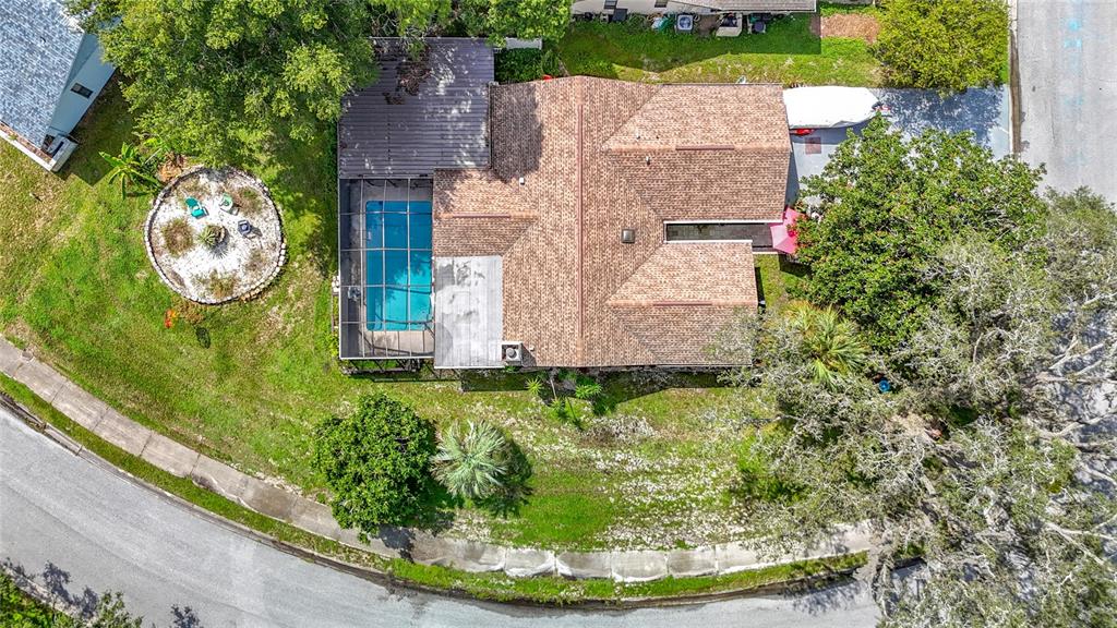 An aerial view shows a house with a shingled roof, screened pool, and large yard — 12529 SHADOW RIDGE BOULEVARD, HUDSON, FL