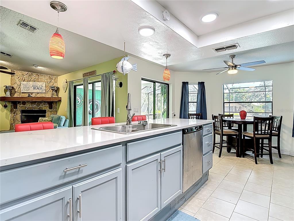 A kitchen with light blue cabinets, a white countertop, and an adjacent dining area — 12529 SHADOW RIDGE BOULEVARD, HUDSON, FL