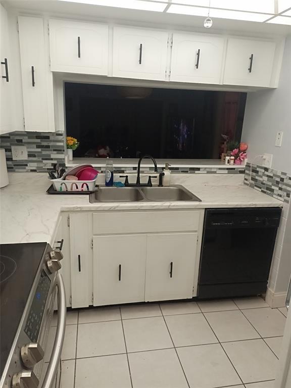 A kitchen features white cabinets, marble-look countertops, a double sink, and a black dishwasher — 3354 SCORECARD DRIVE, NEW PORT RICHEY, FL