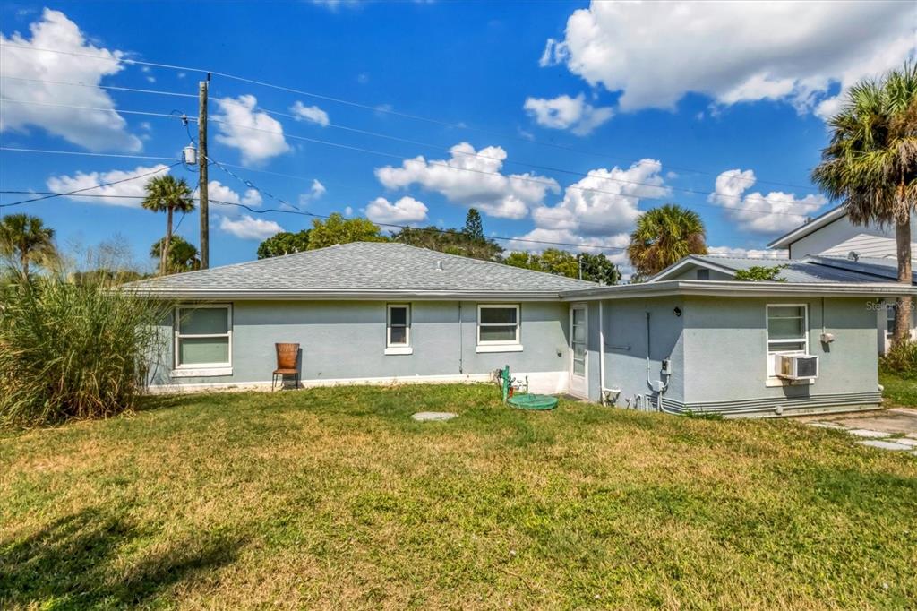 A bright entryway features a window with blinds, a wooden stand, and wall-mounted hooks — 234/236 COLONIA LANE E, NOKOMIS, FL