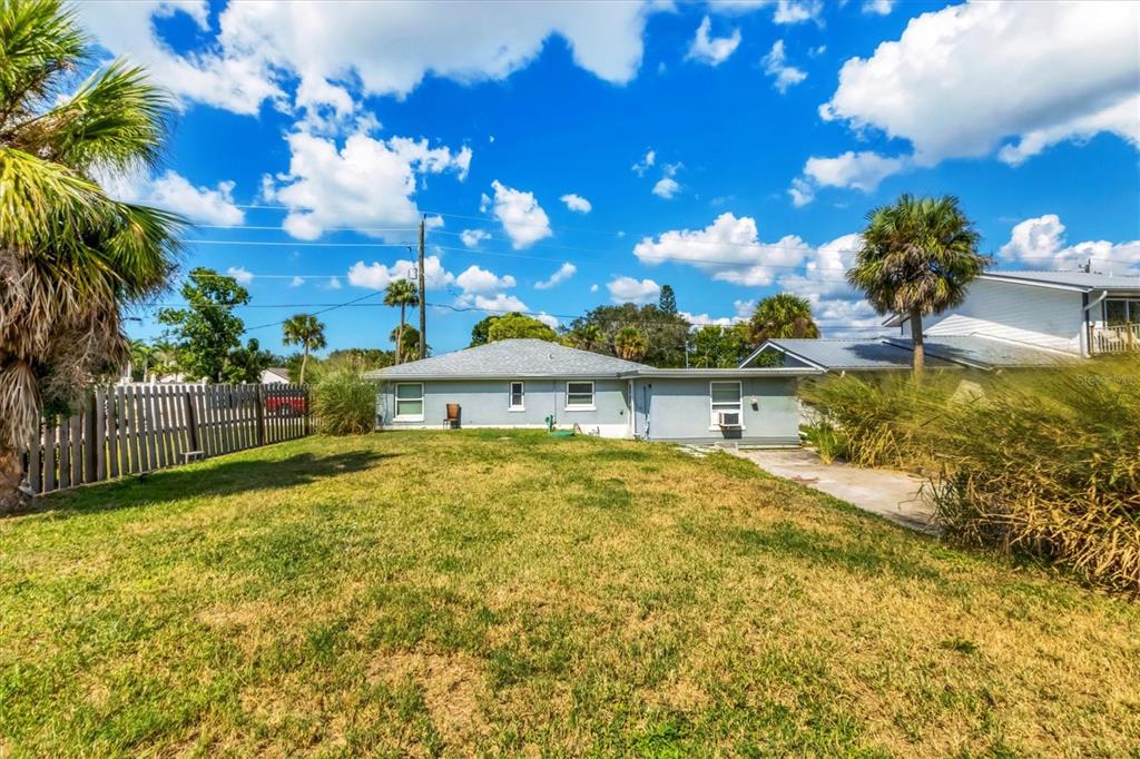 A living area features a black artificial tree, tile flooring, and a small wooden table — 234/236 COLONIA LANE E, NOKOMIS, FL