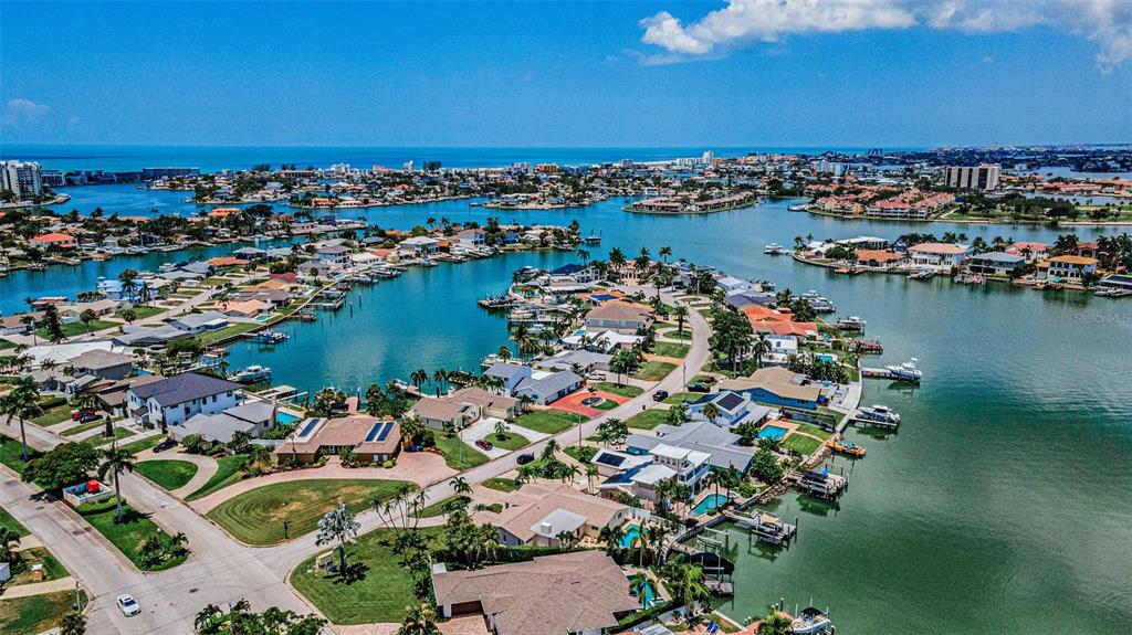 A swimming pool overlooks a canal with a boat lift and palm trees — 7901 10TH AVENUE S, ST PETERSBURG, FL