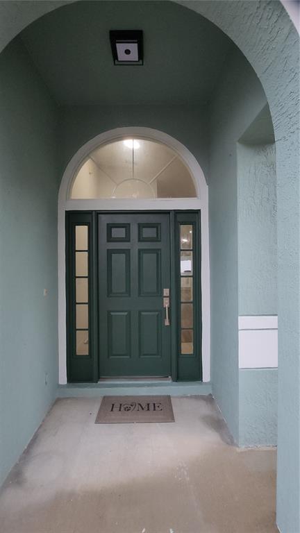 A dark green front door with sidelights and an arched transom window under a covered entryway — 127 ABERDEEN STREET, DAVENPORT, FL