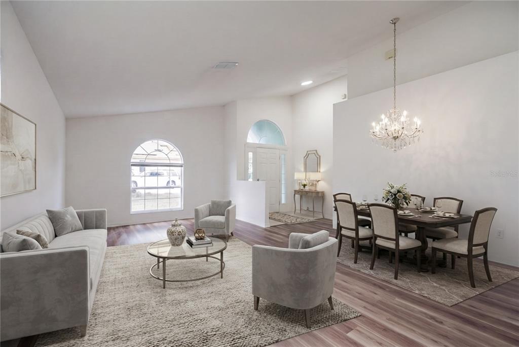 An open-concept living and dining room with white walls, wood-look flooring, and a crystal chandelier — 127 ABERDEEN STREET, DAVENPORT, FL