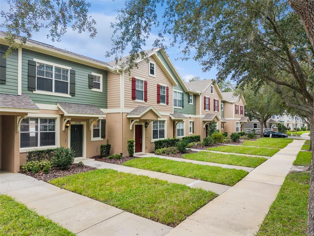 A stone-based monument sign displays the name Lake Reams Townhomes at Lakes of Windermere — 12740 LANGSTAFF DRIVE, WINDERMERE, FL
