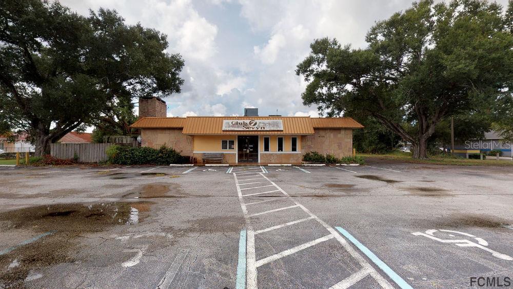 A single-story commercial building with a metal roof and a large paved parking lot — 4701 E MOODY BOULEVARD, BUNNELL, FL