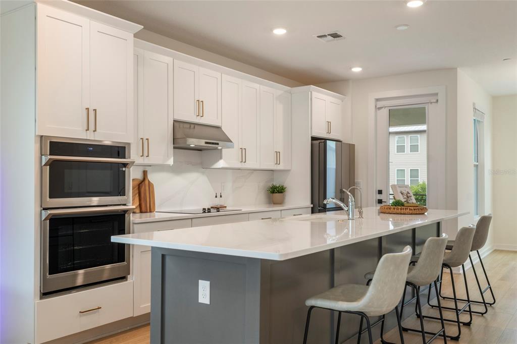 The exterior of a home features a white facade, a brown front door, and landscaping — 12551 WILLSTATTER AVENUE, ORLANDO, FL