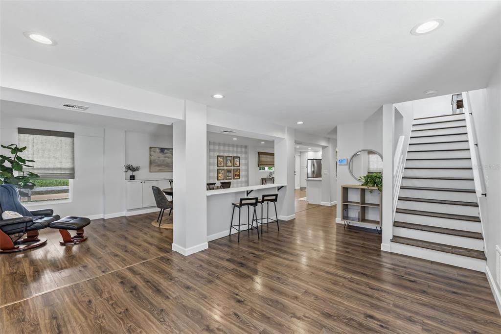 A finished basement features wood-look flooring, a staircase, a breakfast bar, and recessed lighting — 1120 1ST AVENUE N, SAFETY HARBOR, FL