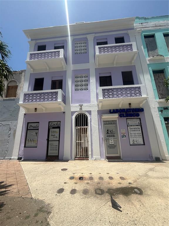 A three-story purple building with two balconies and two ground-level storefronts on a paved street — 260 CONSTITUCION, SAN JUAN, PR