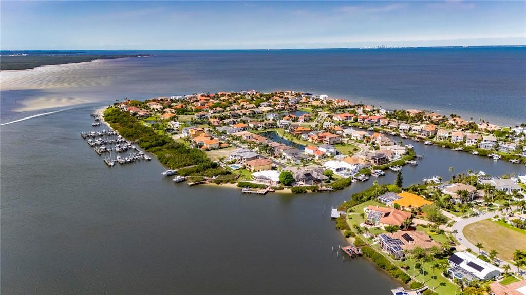 An aerial view shows a residential community on a peninsula surrounded by water — 6107 MARBELLA BOULEVARD, APOLLO BEACH, FL