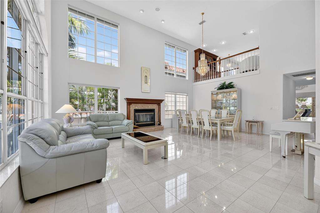 A spacious living and dining area features high ceilings, tile floors, and a fireplace — 6107 MARBELLA BOULEVARD, APOLLO BEACH, FL