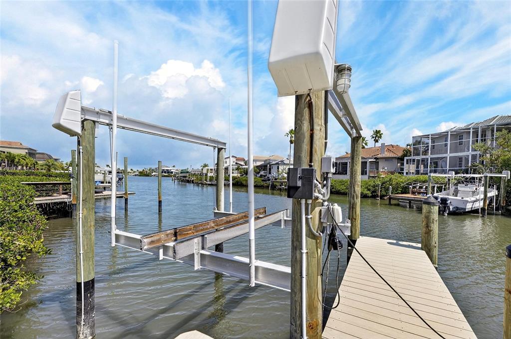 A boat lift stands over a canal next to a wooden dock and mangroves — 6107 MARBELLA BOULEVARD, APOLLO BEACH, FL