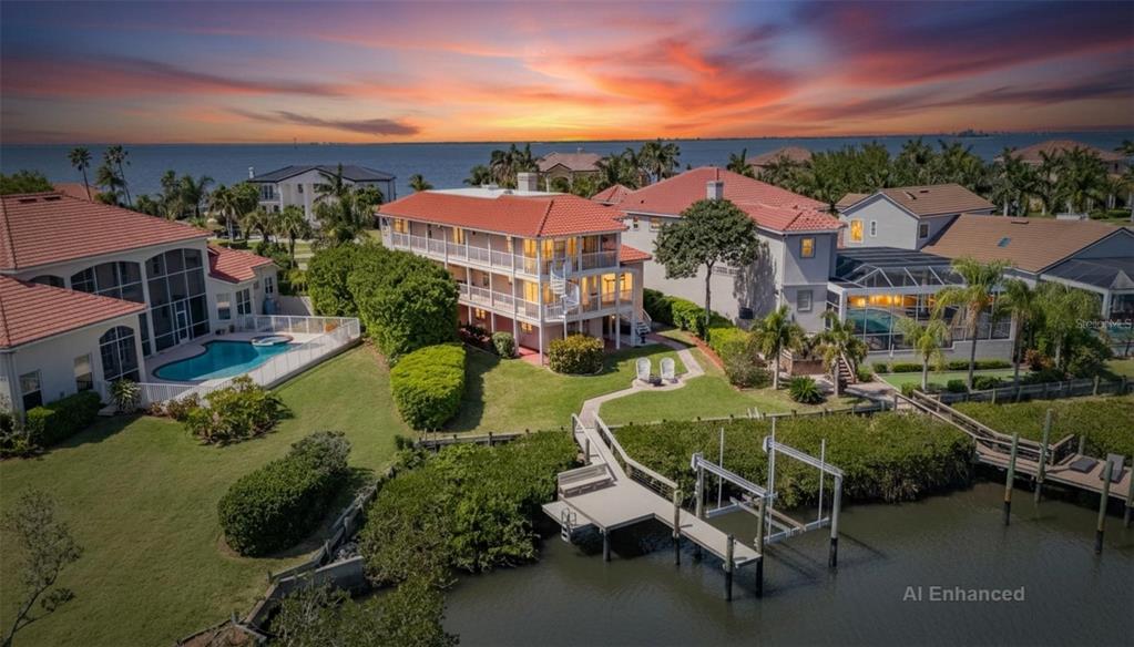 An aerial view shows a multi-story waterfront home with a private dock and swimming pool — 6107 MARBELLA BOULEVARD, APOLLO BEACH, FL