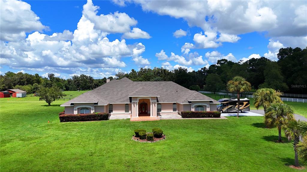 An aerial view of a single-story house with a large lawn and an RV parked nearby — 7571 W HIGHWAY 326, OCALA, FL