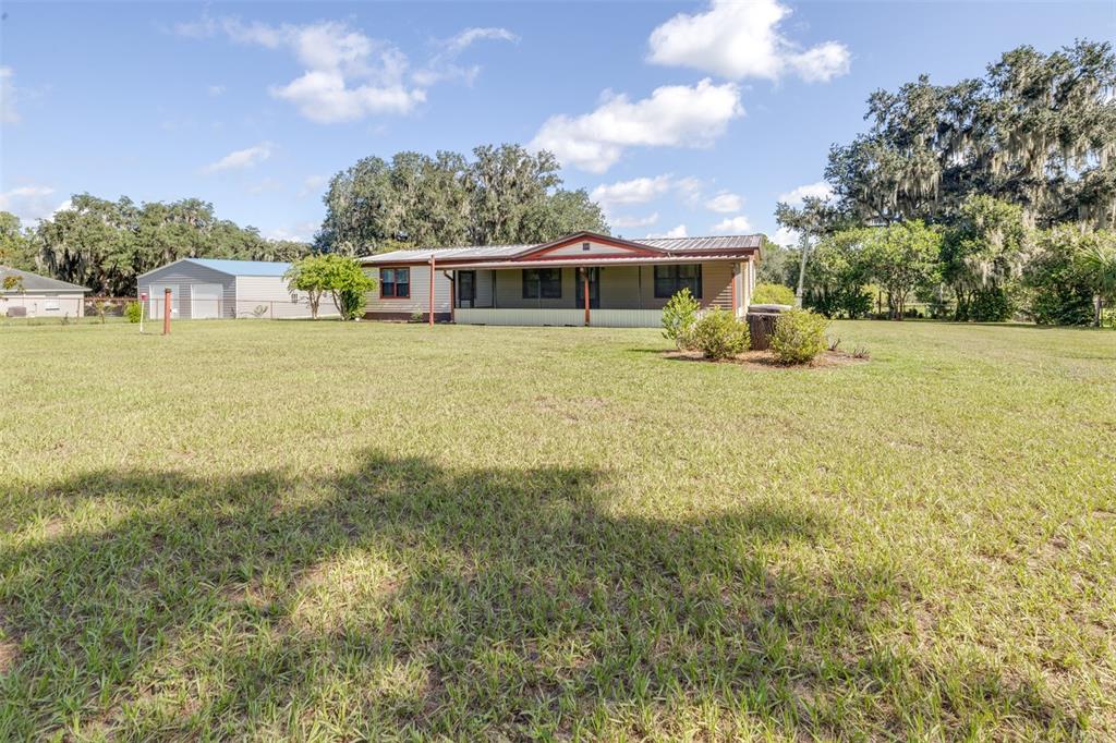 A single-story house with a metal roof and a front porch sits on a lawn — 4605 THOMPSON ROAD, MULBERRY, FL