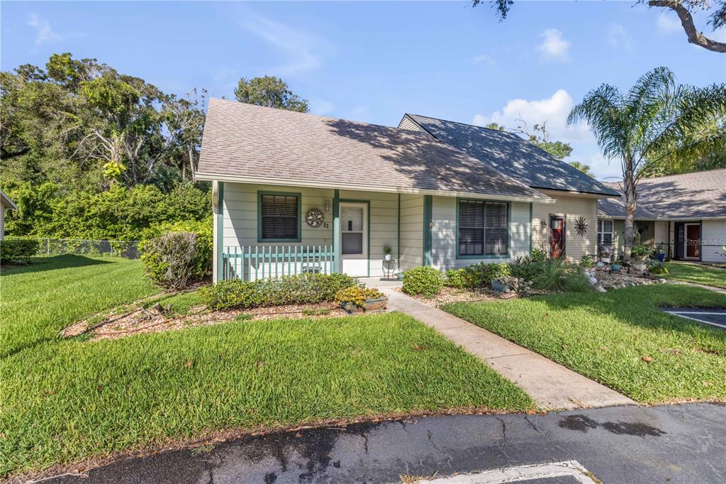 A single-story house with light-colored siding, a shingled roof, and a small front porch — 232 N RIDGEWOOD AVENUE UNIT 23, EDGEWATER, FL